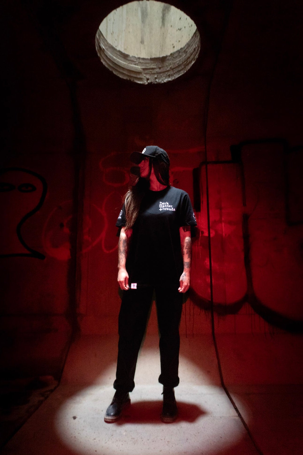 Female model front view wearing the Dark Matter Threads Protected graphic printed unisex t-shirt, 100% cotton.