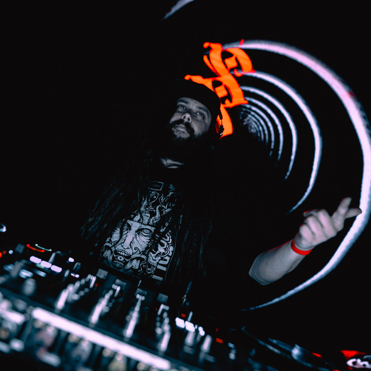 DJ Substance at work with turntables and light effects in a dark setting