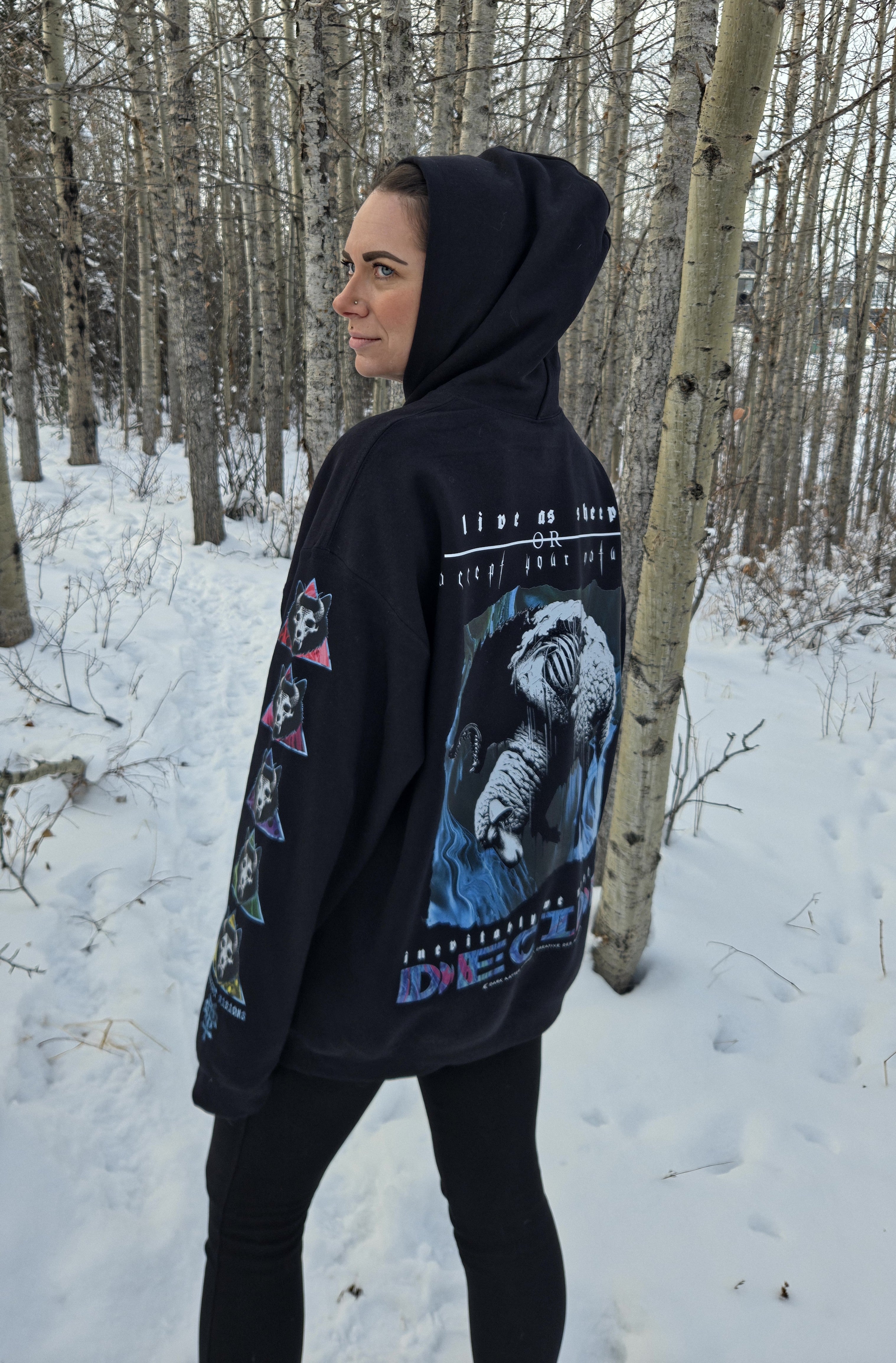 Female model wearing the Dark Matter Threads black unisex Decide graphic hoodie, back view with sleeve designs visible.