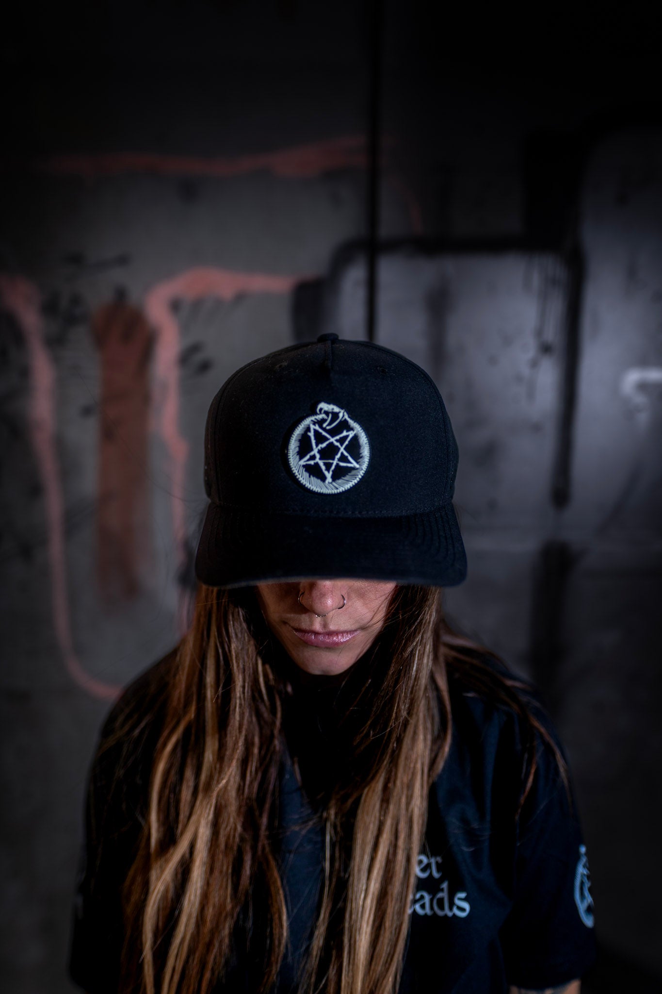 Female model front view wearing the Dark Matter Threads Void Marker unisex snapback hat.