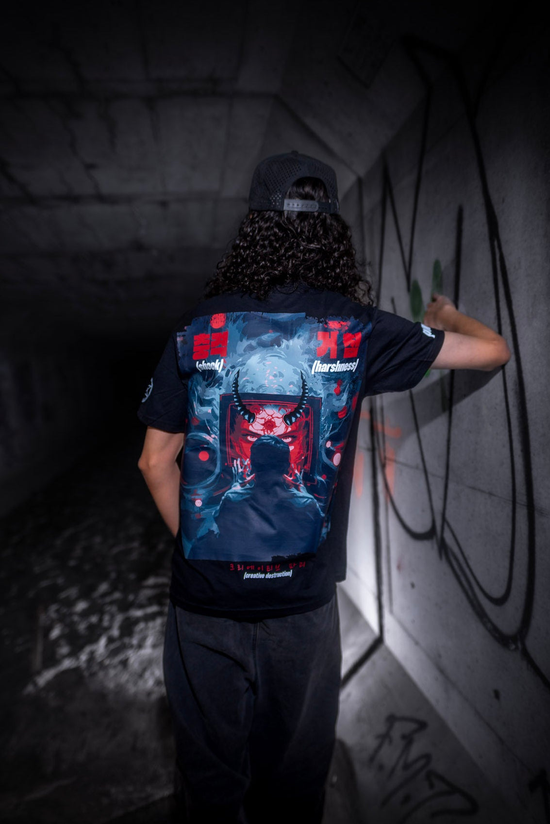 Male model back view wearing the Dark Matter Threads Dark Matter Tracks black unisex t-shirt with graphic artwork, Ponda collaboration.