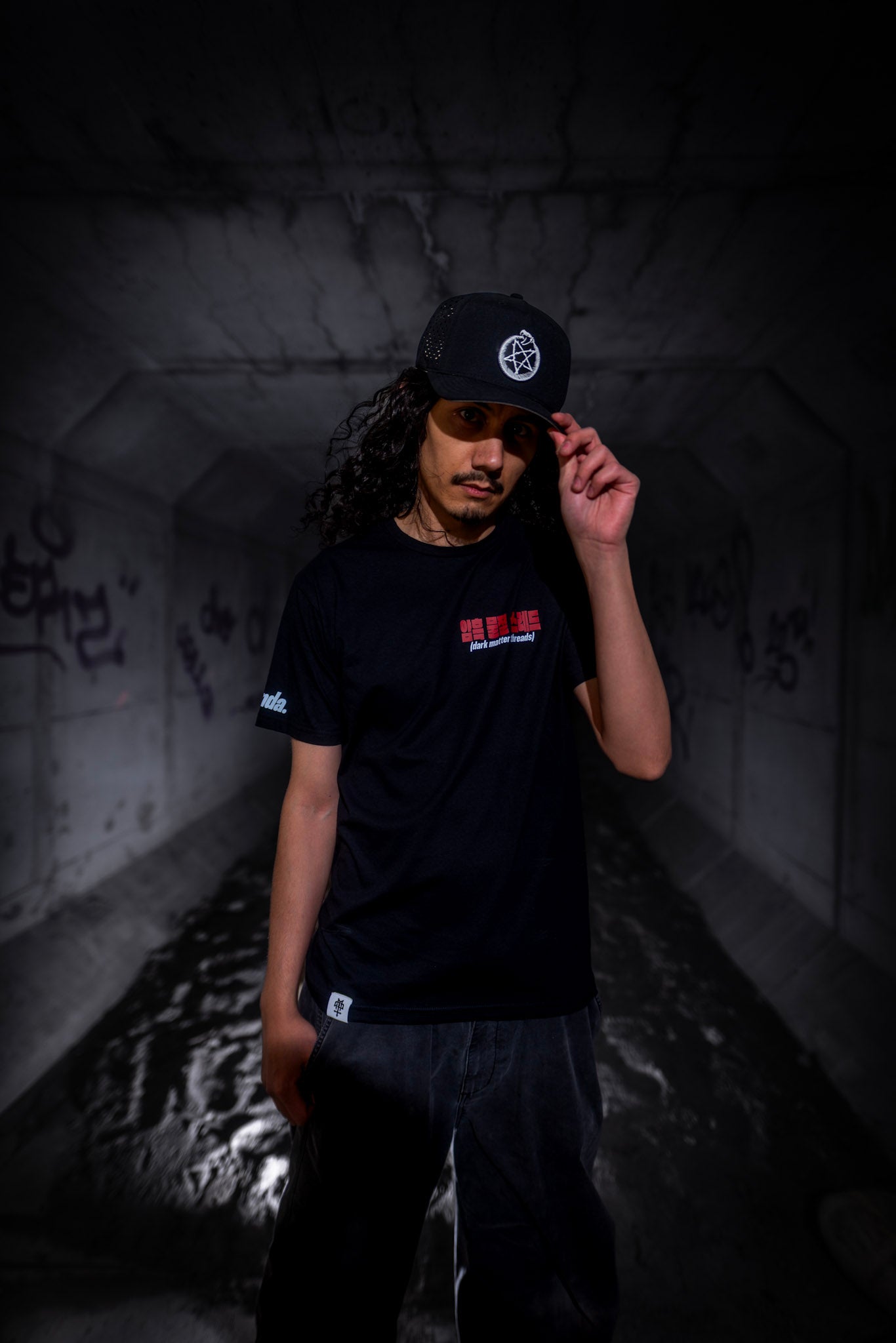 Male model front view wearing the Dark Matter Threads Dark Matter Tracks black unisex graphic t-shirt, Ponda collaboration.