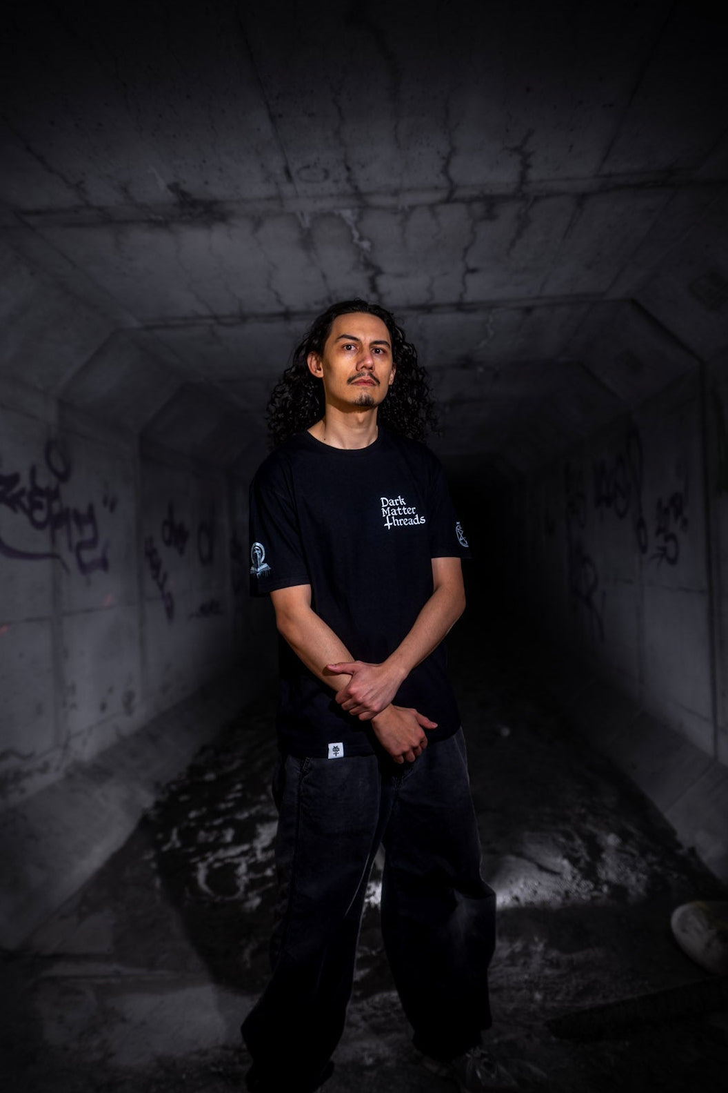 Male model front view wearing the Dark Matter Threads Protected graphic printed unisex t-shirt, 100% cotton.